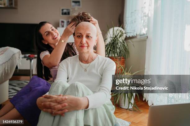 a woman and a wig after chemotherapy - toupee stock pictures, royalty-free photos & images