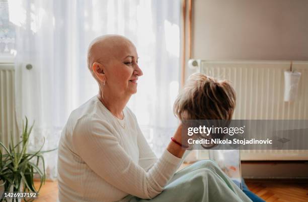 eine frau und eine perücke nach der chemotherapie - perücke stock-fotos und bilder