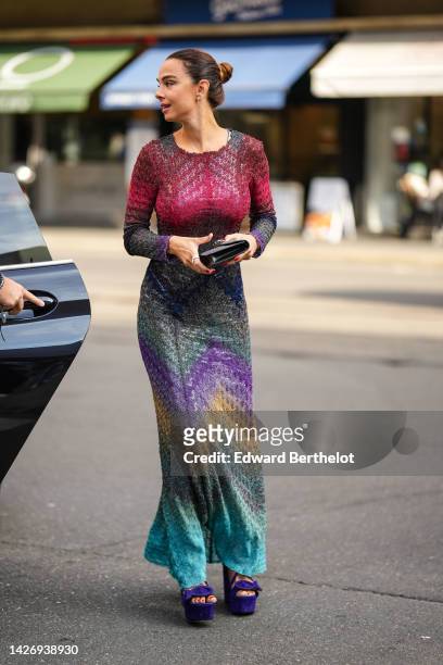 Guest wears diamonds earrings, a burgundy / gray / purple / brown / blue embroidered striped print pattern long sleeves / long dress, a gray felt...
