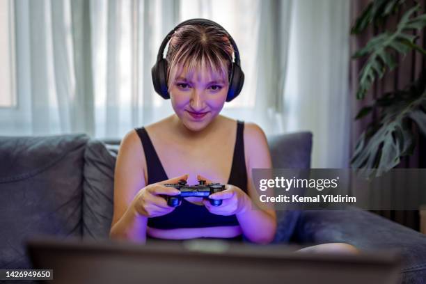 giovane giocatore che gioca al gioco per computer sul laptop - joypad foto e immagini stock