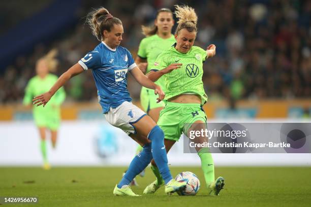 Julia Hickelsberger of TSG 1899 Hoffenheim is tackled by Felicitas Rauch of VfL Wolfsburg during the Flyeralarm Frauen-Bundesliga match between TSG...