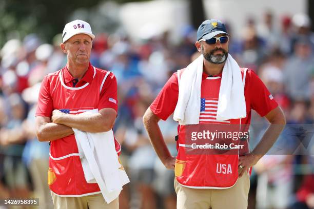 Caddies Jim Mackay and Michael Greller watch play on the second green during Saturday afternoon four-ball matches on day three of the 2022 Presidents...