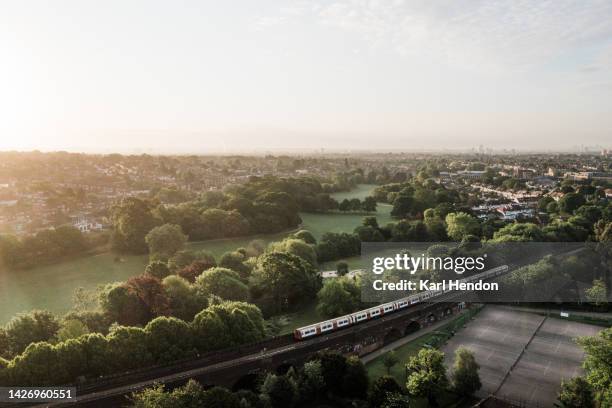 an aerial view of a tube train on a viaduct in london, uk - parkland - southgate stock pictures, royalty-free photos & images