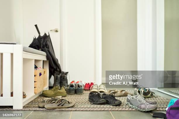 shoes scattered on door mat at home - corridor bildbanksfoton och bilder
