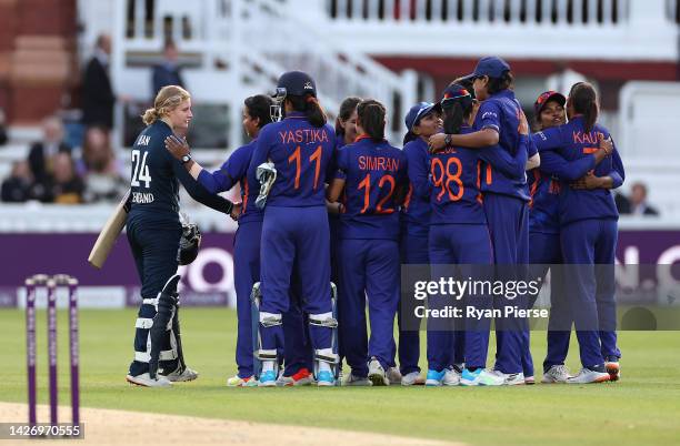 Charlie Dean of England shakes hands with Deepti Sharma of India after she was run out by Deepti Sharma of India to claim victory during the 3rd...