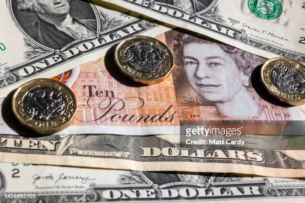 In this photo illustration, U.S. Dollar bills are are pictured with British GDP £1 coins and notes on September 24, 2022 in Bath, England. The UK...