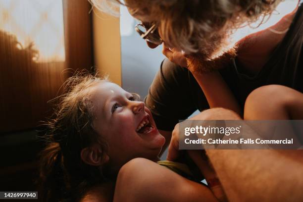 a heartwarming image of a delighted little girl in the arms of her father - love emotion stock pictures, royalty-free photos & images