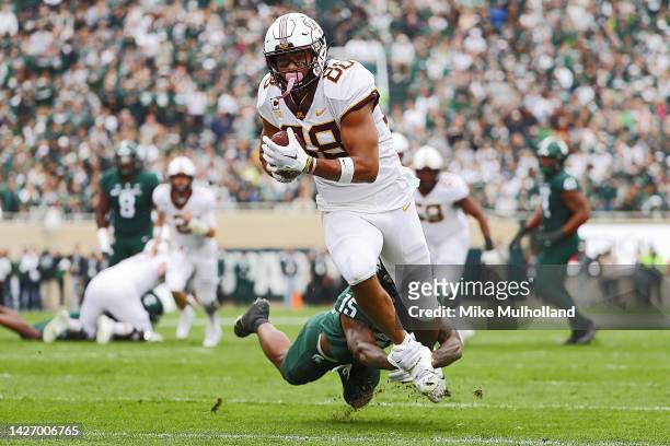 Brevyn Spann-Ford of the Minnesota Golden Gophers is tackled by Angelo Grose of the Michigan State Spartans after catching a first down pass in the...
