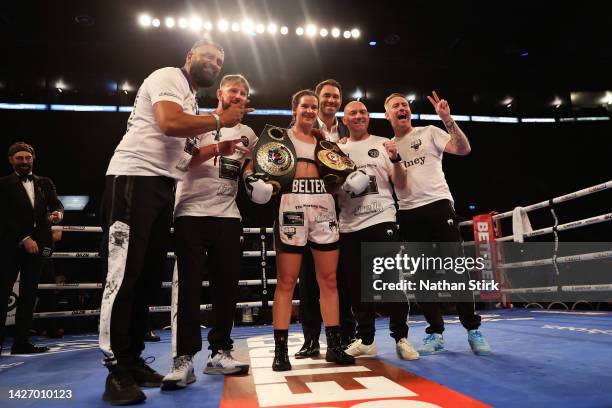 Terri Harper poses with their team and Eddie Hearn, Chairman of Matchroom Sport while holding the WBA and IBO World Super Welterweight Title belts...