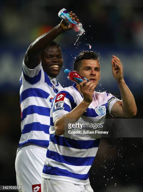 Taye Taiwo of Queens Park Rangers pours water over team mate Joey Barton as they celebrate victory after the Barclays Premier League match between...