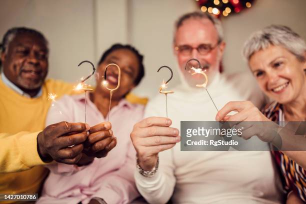 multiethnische gruppe älterer freunde, die neujahr 2023 feiern - 40 year old black man stock-fotos und bilder