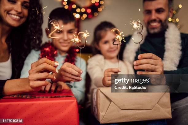 young family celebrating new year 2023 - new year's eve children stock pictures, royalty-free photos & images
