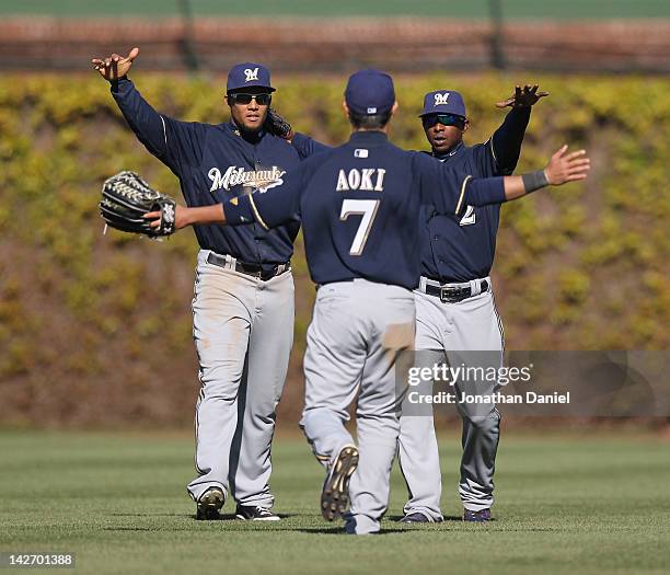 Carlos Gomez and Nyjer Morgan of the Milwaukee Brewers welcome Norichika Aoki to celebrate a win over the Chicago Cubs at Wrigley Field on April 11,...