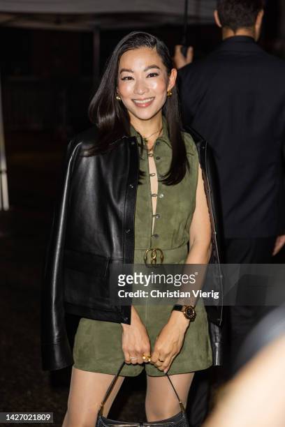 Arden Cho wears green belted dress, black leather jacket outside Bally during the Milan Fashion Week - Womenswear Spring/Summer 2023 on September 24,...