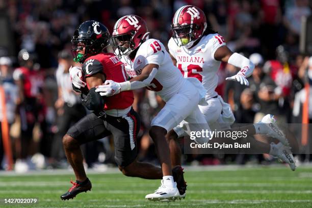 Tre Tucker of the Cincinnati Bearcats runs with the ball while being tackled by Josh Sanguinetti of the Indiana Hoosiers in the second quarter at...