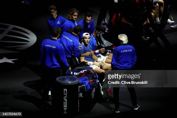 Matteo Berrettini and Novak Djokovic of Team Europe take advice from Roger Federer on the team bench in the match between Alex De Minaur and Jack...