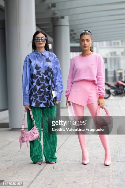 Angela Rozas Saiz wearing a striped blue shirt with embroidery, green striped pants and pink bag and shoes and Aida Domènech wearing a pink wallet...