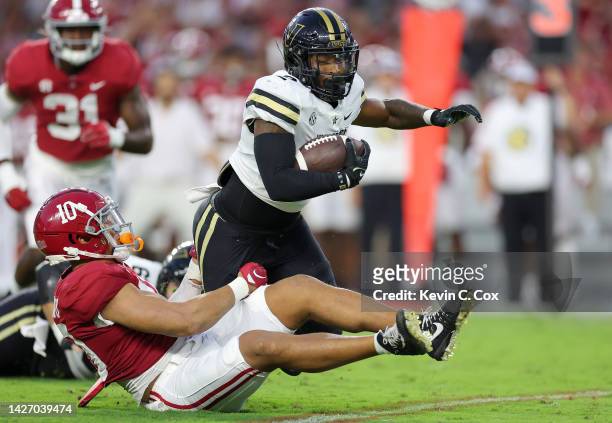 Henry To'oTo'o of the Alabama Crimson Tide tackles Ray Davis of the Vanderbilt Commodores during the first half of the game at Bryant-Denny Stadium...