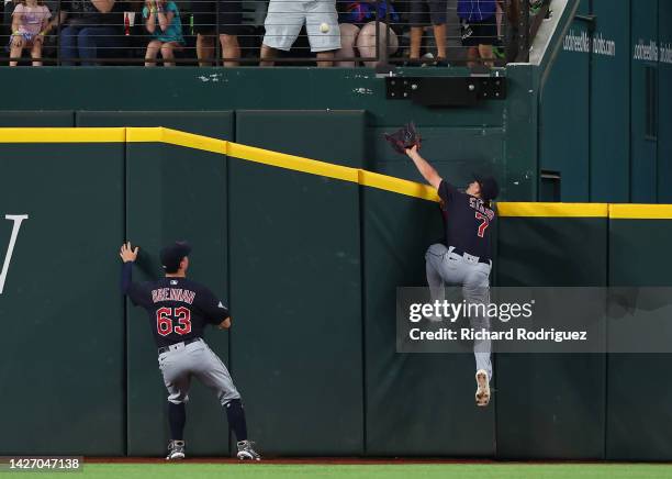 Will Brennan and Myles Straw of the Cleveland Guardians chase a home run hit by Marcus Semien of the Texas Rangers in the third inning at Globe Life...