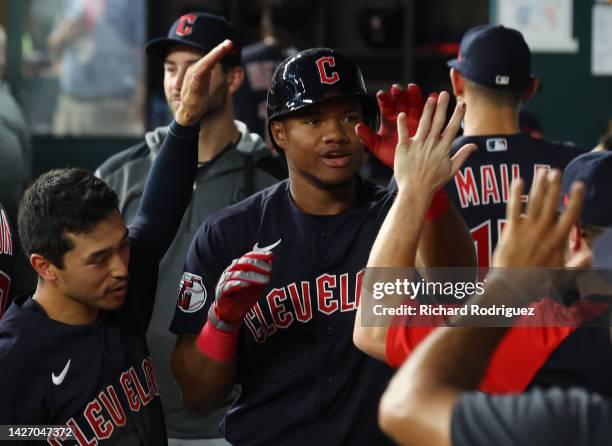 Oscar Gonzalez of the Cleveland Guardians is celebrated in the dugout after a solo home run in the fifth inning against the Texas Rangers at Globe...