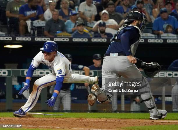 Drew Waters of the Kansas City Royals runs past Curt Casali of the Seattle Mariners to score on a Bobby Witt Jr. Single in the fourth inning at...