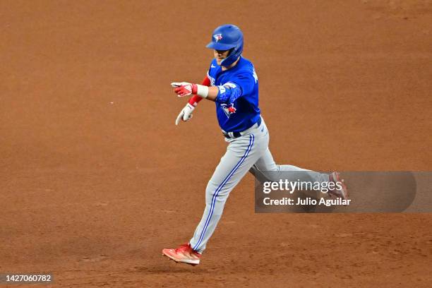 Whit Merrifield of the Toronto Blue Jays gestures to the dugout after hitting a three-run home run in the seventh inning against the Tampa Bay Rays...