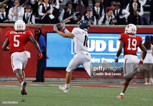 Luke McCaffrey of the Rice Owls catches a pass for a touchdown as he runs in front of Alex Hogan of the Houston Cougars and Hasaan Hypolite in the...