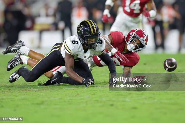 Devin Boddie Jr. #6 of the Vanderbilt Commodores and Malachi Moore of the Alabama Crimson Tide look at the ball after a broken up pass during the...