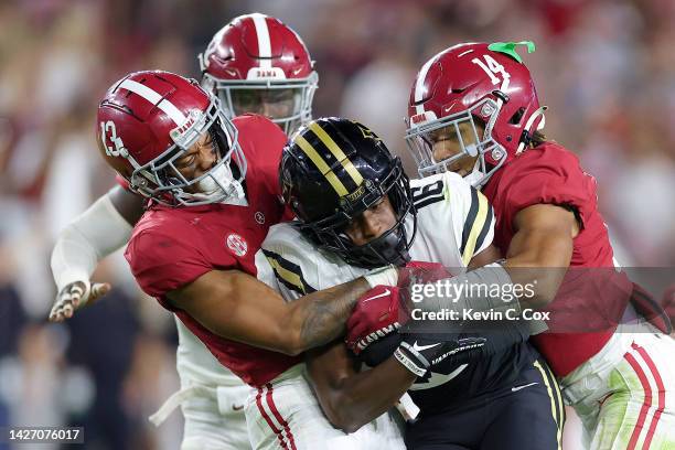 Jayden McGowan of the Vanderbilt Commodores is tackled by Aaron Anderson and Brian Branch of the Alabama Crimson Tide during the second half of the...
