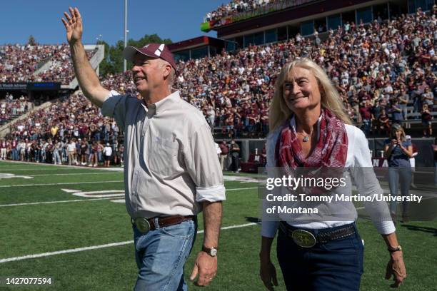 Montana Gov. Greg Gianforte and his wife Susan Gianforte walk onto the field for the coin toss during Montana’s 53-16 homecoming victory over...