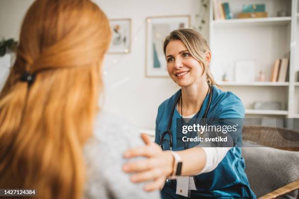 nurse in home visit for christmas - young adult patient stock pictures, royalty-free photos & images