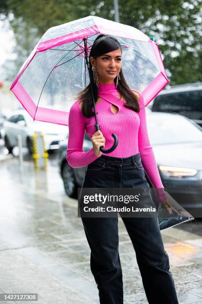 Elisa Maino is seen wearing a pink sweater, black denim pants, silver MSGM bag and pink heels outside the MSGM show during the Milan Fashion Week -...