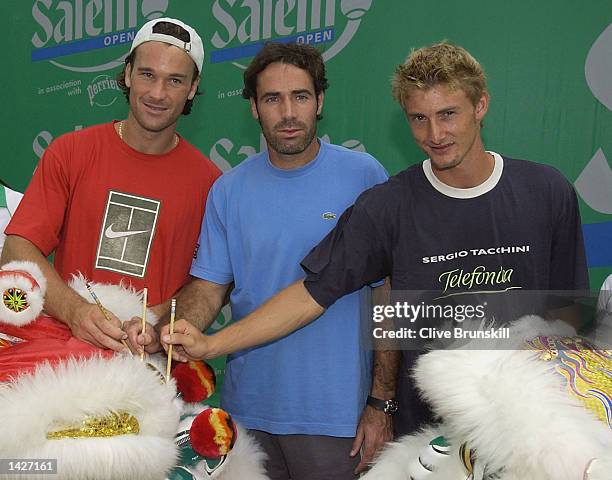 Spains Carlos Moya, Alex Corretja and Juan Carlos Ferrero paint a dot on the dragons eye for good luck during the opening ceremony of the Salem Open...