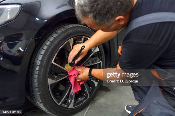 professional worker cleaning car rim stock photo - auto detailing stock pictures, royalty-free photos & images