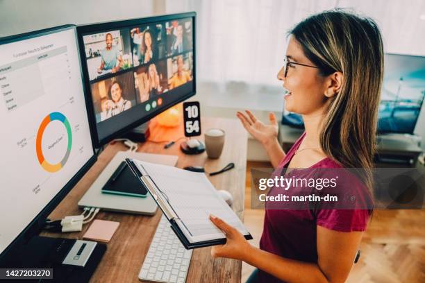 donna alla scrivania in piedi home office che parla in videochiamata aziendale - un giorno nella vita foto e immagini stock