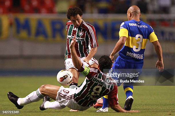 Wellinton Nem and Fred of Fluminense struggle for the ball with Clemente Rodriguez of Boca Juniors during a match between Fluminense and Boca Juniors...