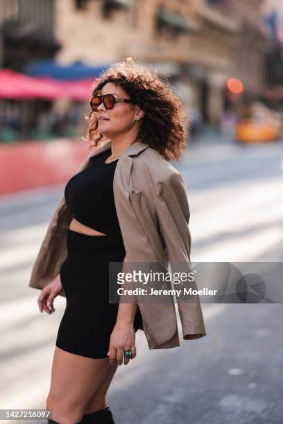 Dayami Candebat is seen wearing brown sunglasses, a black Aritzia cut-out short dress, beige blazer jacket from H&M, earrings and necklace from Nina...