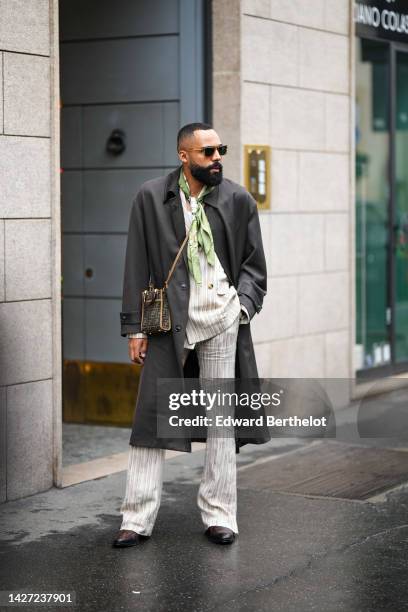 Guest wears brown sunglasses, a white latte and green print pattern silk scarf, a white tank-top, a beige striped print pattern blazer jacket,...