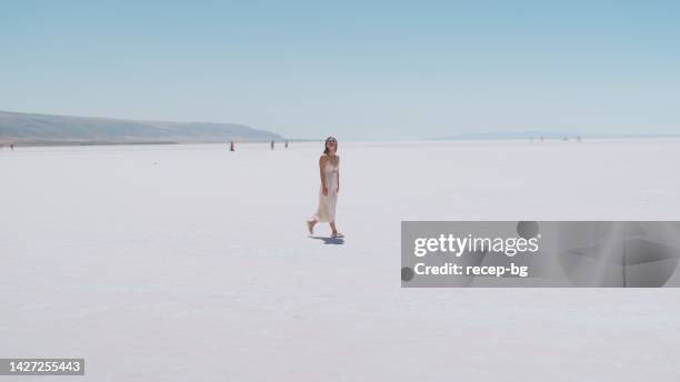young female tourist walking on white salt in salt lake türkiye - woman fashion long dress stock pictures, royalty-free photos & images