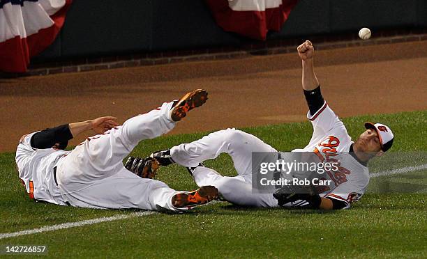 Mark Reynolds and Nolan Reimold of the Baltimore Orioles miss a double hit by Mark Teixeira of the New York Yankees during the tenth inning of the...