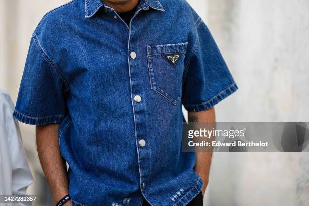 Guest wears a navy blue denim short shirt from Prada, outside Prada, during the Milan Fashion Week - Womenswear Spring/Summer 2023 on September 22,...