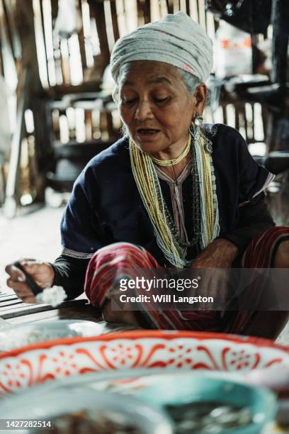 hmong hilltribe woman eating chiang mai, thailand - live chicken market stockfoto's en -beelden