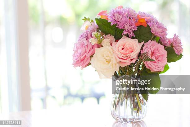 bouquet of flowers on table near window - mazzo di fiori foto e immagini stock