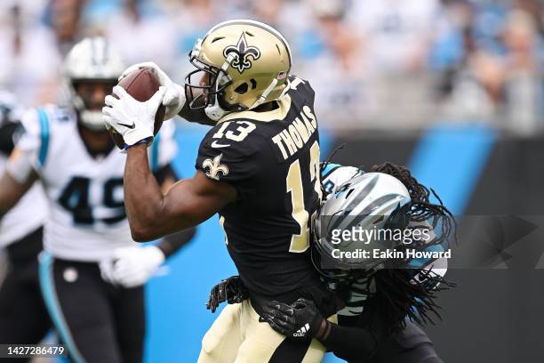 Michael Thomas of the New Orleans Saints catches a pass while being tackled by Donte Jackson of the Carolina Panthers during the first quarter at...