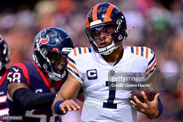 Quarterback Justin Fields of the Chicago Bears runs past linebacker Christian Kirksey of the Houston Texans during the first half at Soldier Field on...