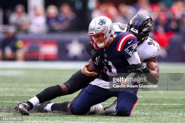 Linebacker Odafe Oweh of the Baltimore Ravens tackles quarterback Mac Jones of the New England Patriots during the first half at Gillette Stadium on...