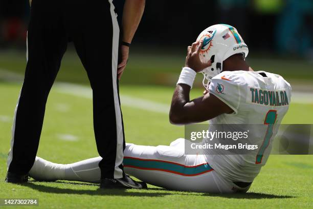 Quarterback Tua Tagovailoa of the Miami Dolphins sits on the turf during the first half of the game against the Buffalo Bills at Hard Rock Stadium on...