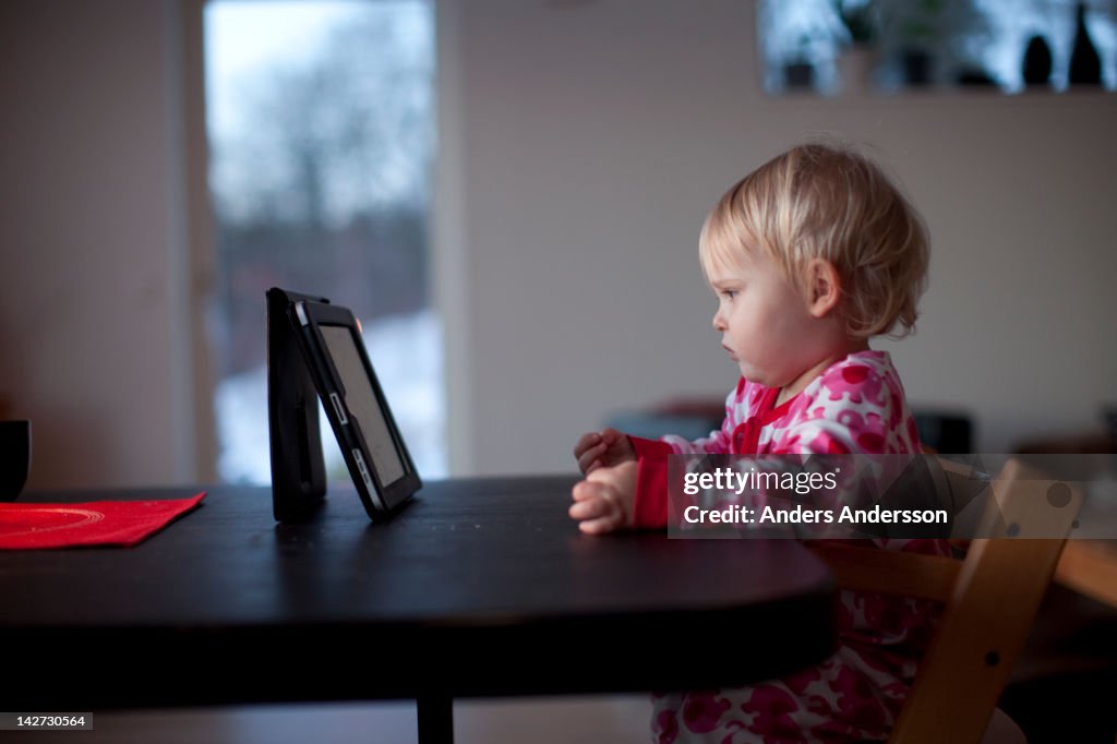 Small child wathing movie on digital tablet