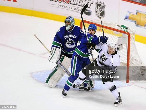 Kevin Bieksa of the Vancouver Canucks checks Trevor Lewis of the Los Angeles Kings in front of the net in Game One of the Western Conference...