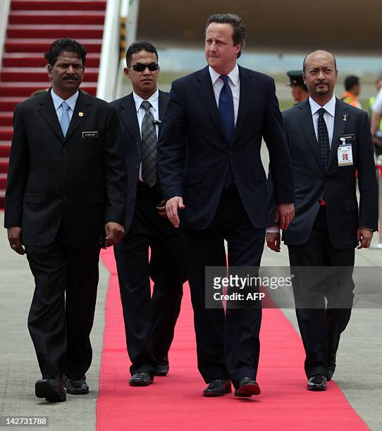 British Prime Minister David Cameron accompanied by Malaysian Deputy Minister of Foreign Affairs A. Kohilan walks on a red carpet as he arrives at...